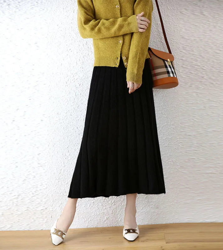 Women's flared pleat wool skirt in Onyx, model carrying bag over shoulder — From Borcelleclothes.