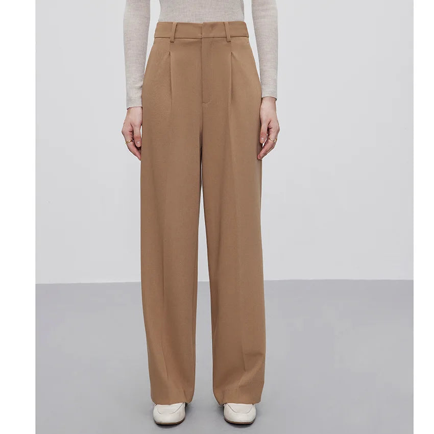 Woman wears Almond Frost trousers with arms down, showing relaxed silhouette and clean lines. From Borcelleclothes.
