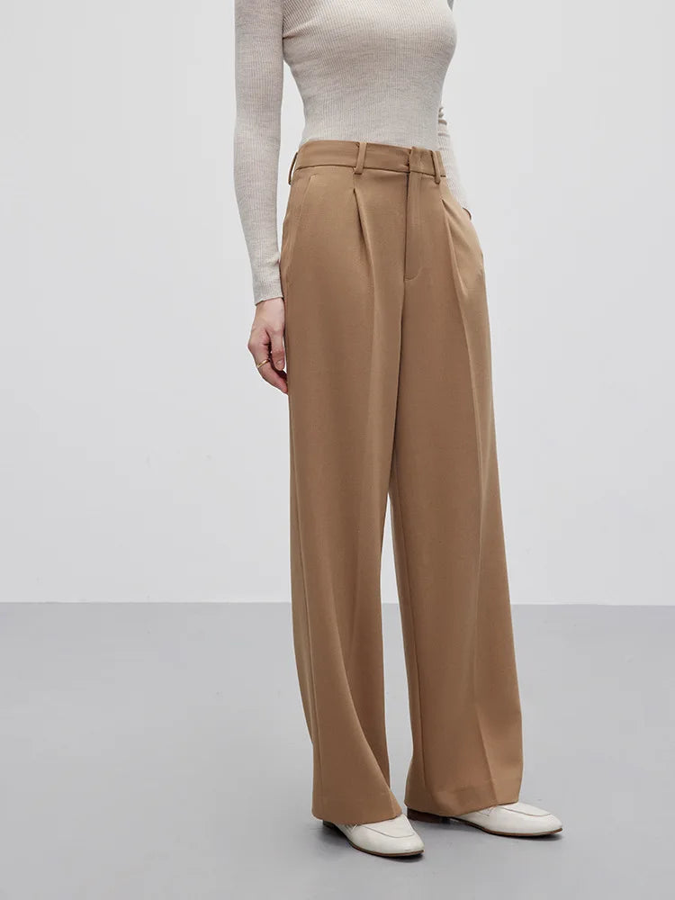Women’s fluid wool-blend trousers in Almond Frost, featuring a soft tailored drape, front tucks, and a clean waistband with belt loops. From Borcelleclothes.