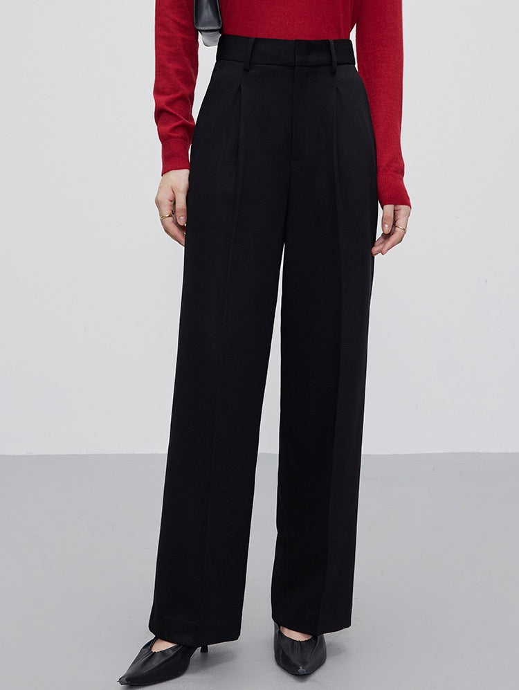 Women’s fluid wool-blend trousers in Onyx, featuring a soft tailored drape, front tucks, and a clean waistband with belt loops. From Borcelleclothes.