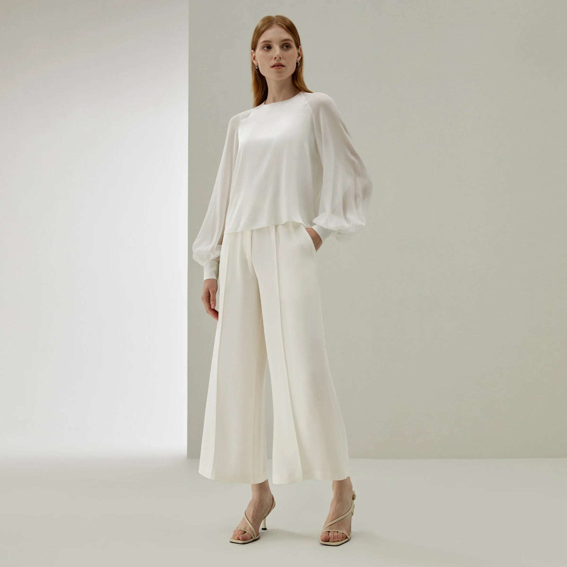 Model in Pearl Bush wide-leg silk trousers, hand resting in the pocket — a moment of quiet poise and tactile elegance. From Borcelleclothes.