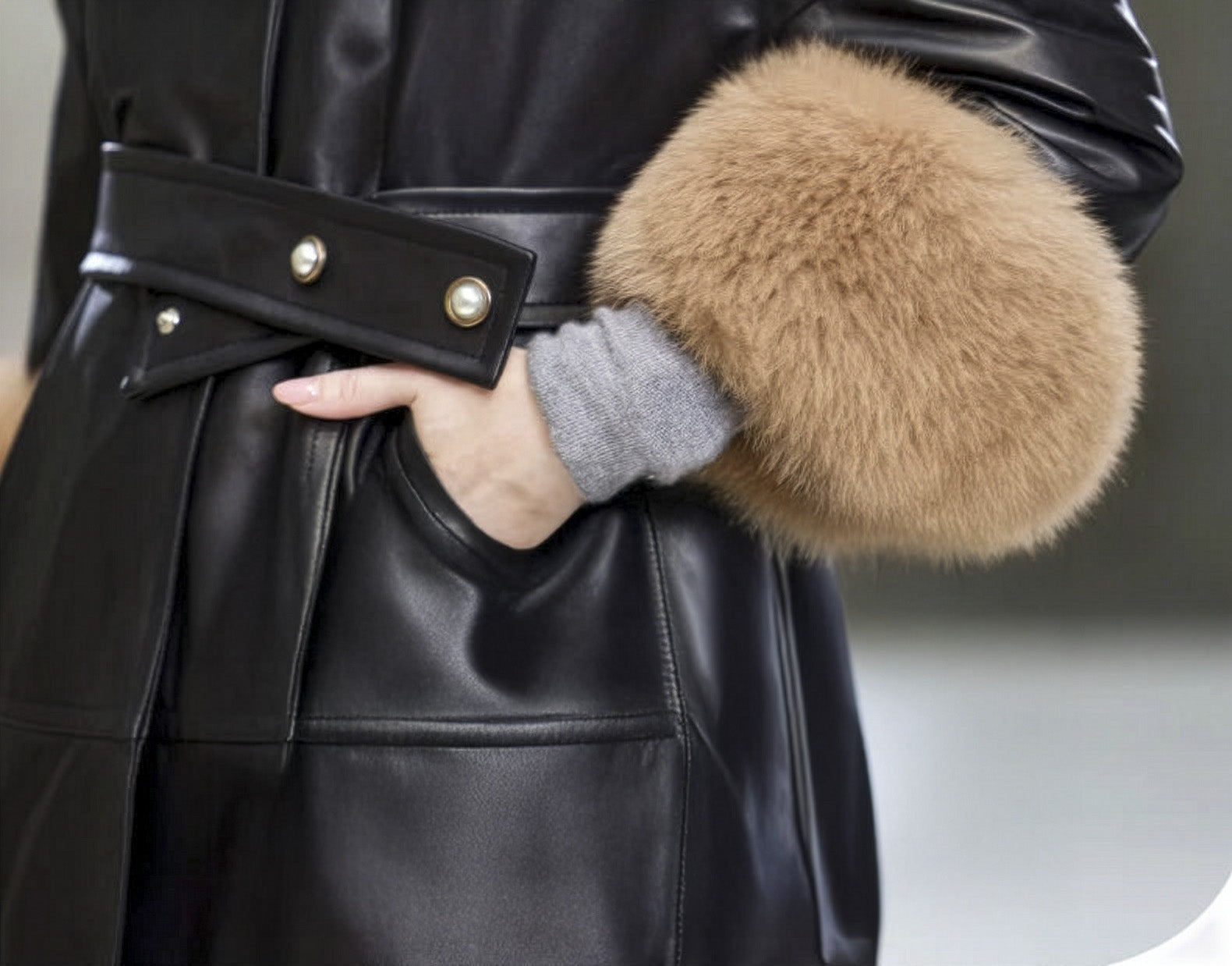 Hand placed in side pocket of the Onyx sheepskin coat, revealing relaxed sleeve fold and texture. — From Borcelleclothes.