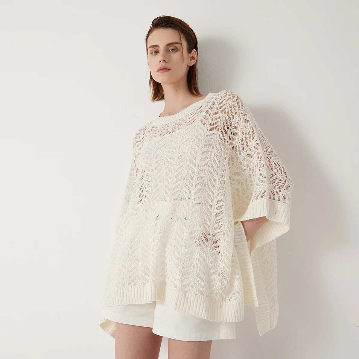 Women's linen lace poncho in Pearl Bush - in an airy rectangular cut with abstract openwork knit and underarm tacking for sculpted drape. From Borcelleclothes.