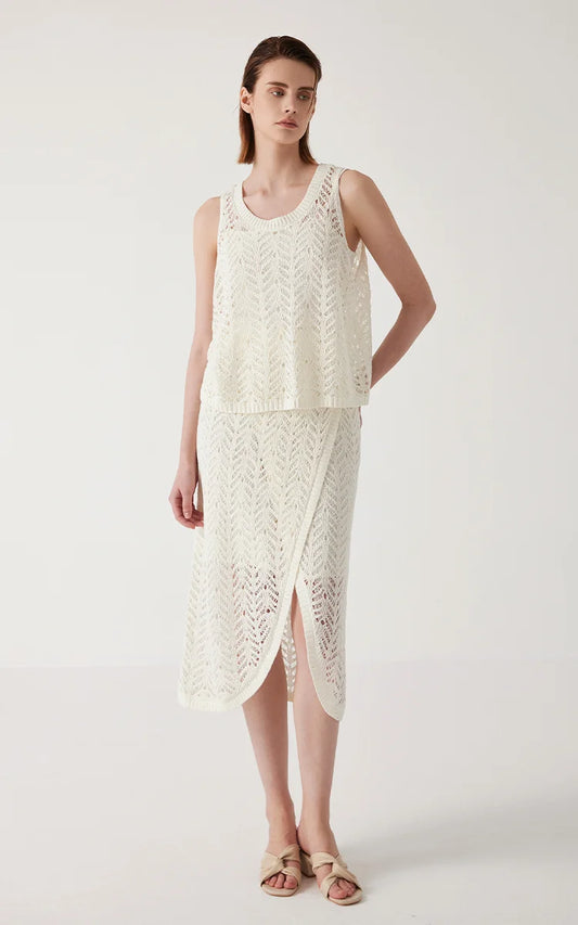 Model in Pearl Bush linen lace skirt with one hand behind her back, showing the skirt’s side relief and movement. From Borcelleclothes.