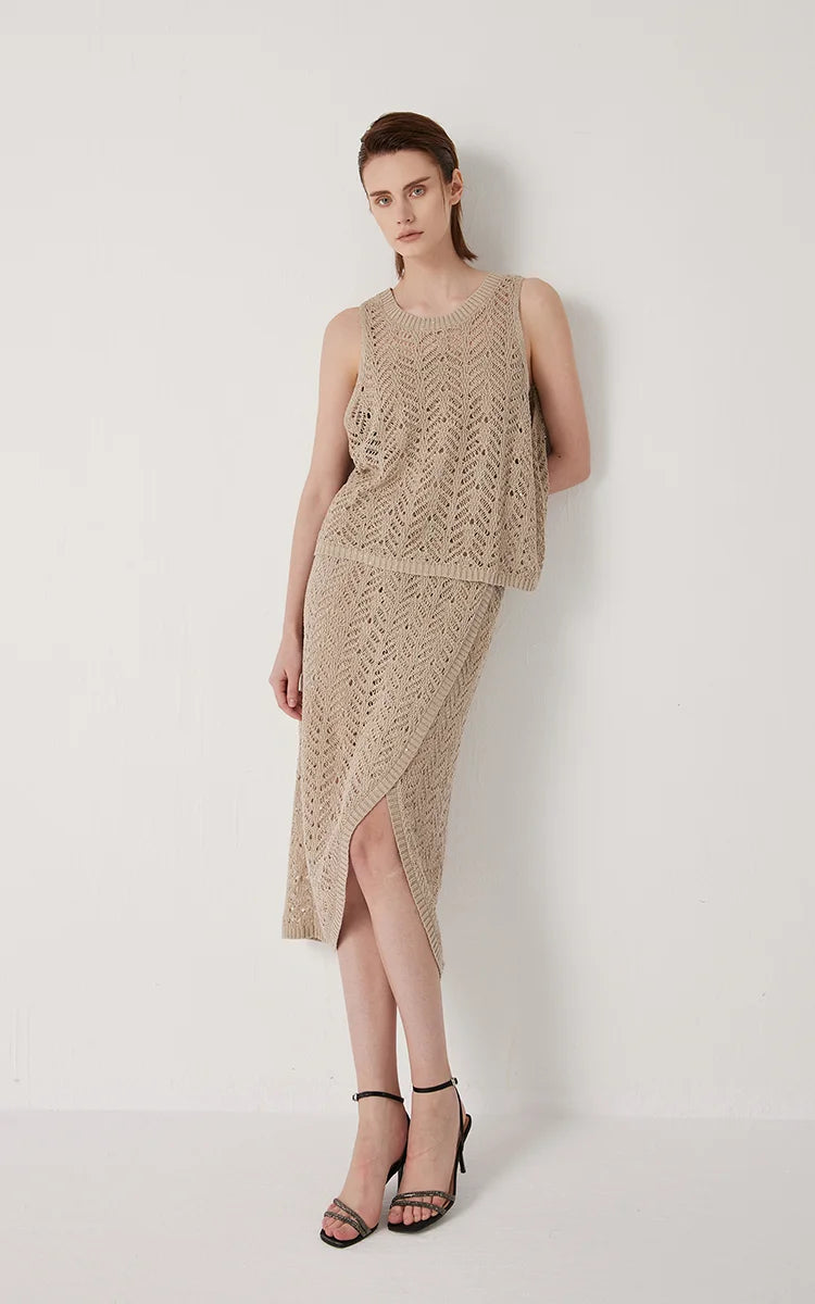 Model in Vanilla linen lace skirt leaning against the wall, light filtering through the open knit. From Borcelleclothes.