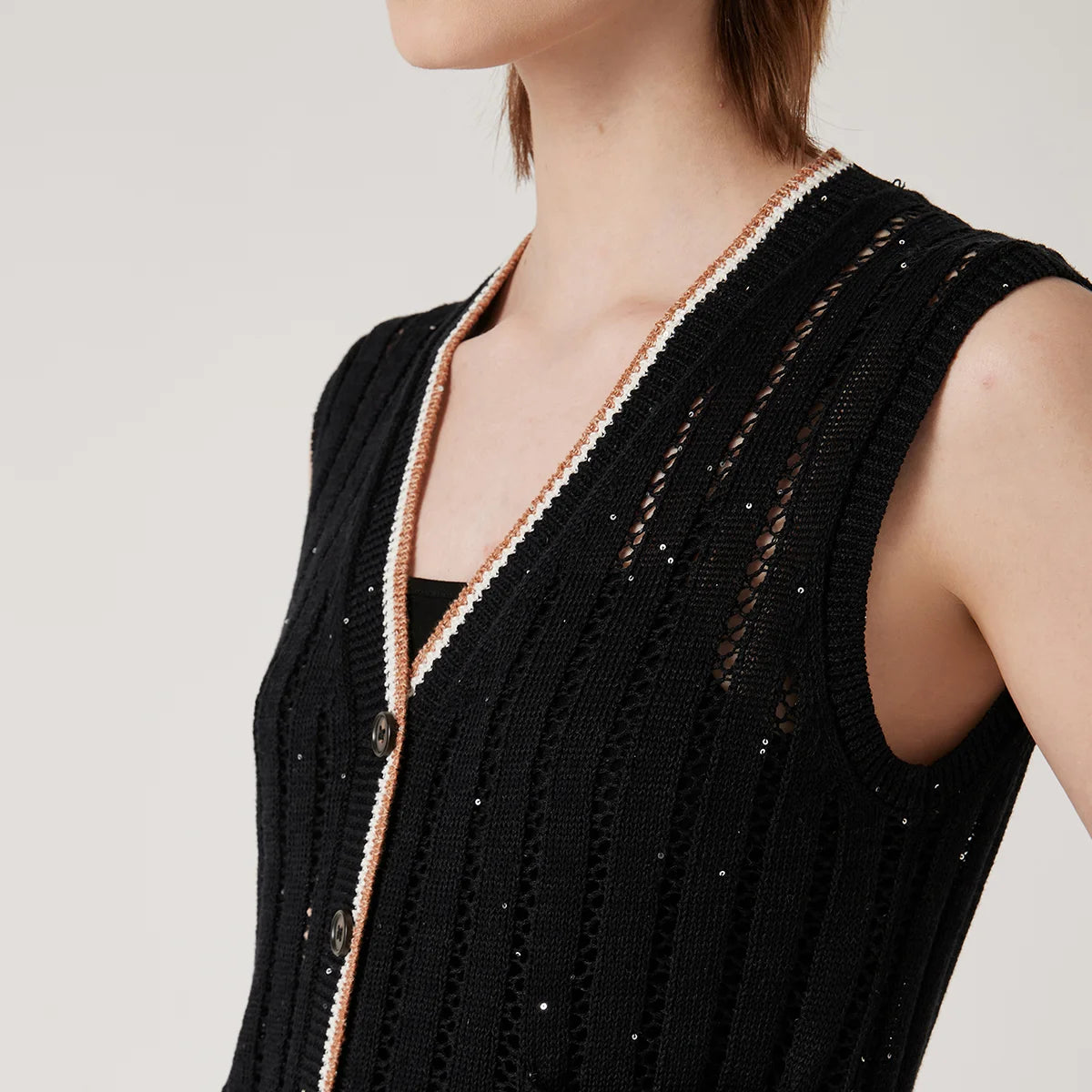 Upper view of black lace vest in Onyx, highlighting neckline, horn buttons, and two-tone contrast stripe along the ribbed edge. From Borcelleclothes.