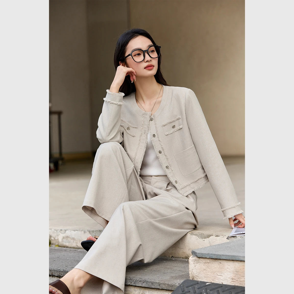 Model sitting on steps in the Martini set, resting her cheek on one hand in a thoughtful pose. From Borcelleclothes.