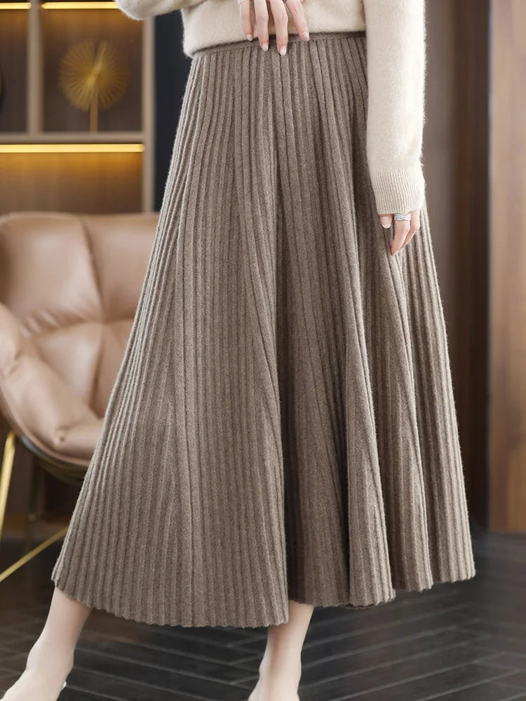 Model wearing merino skirt with textured pleats in Almond Frost, leg extended to the side — From Borcelleclothes.