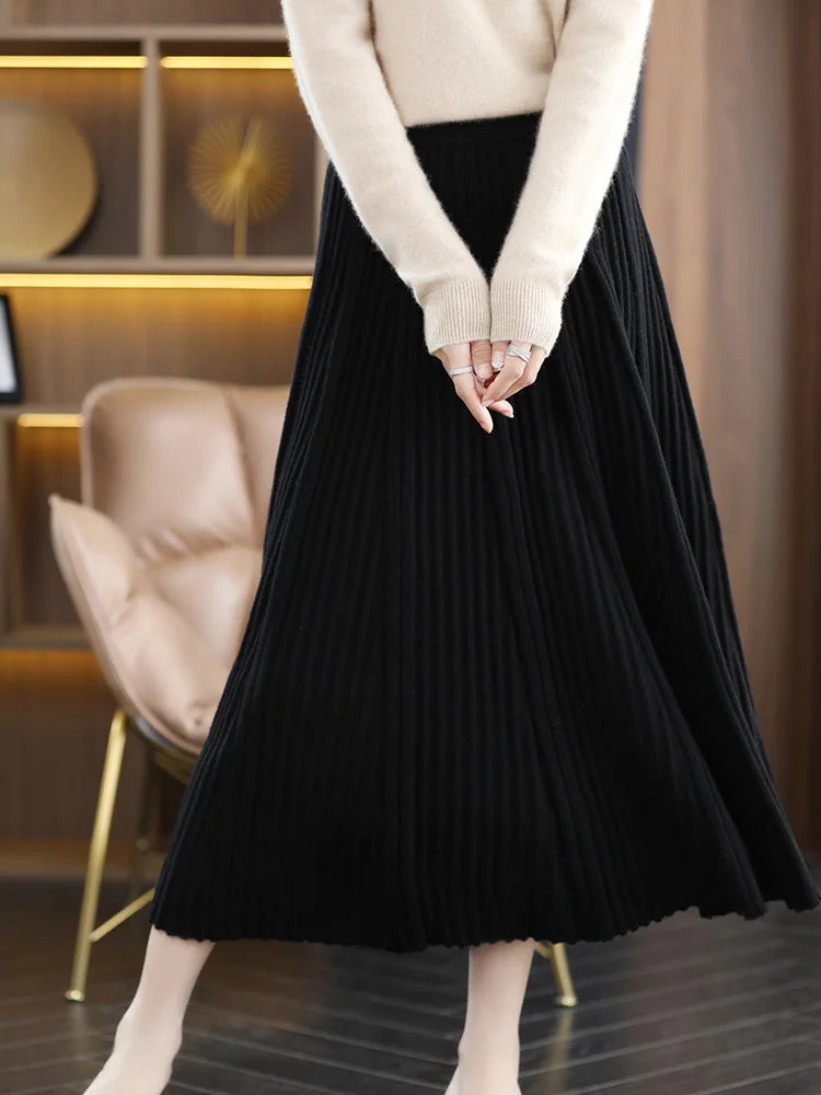 Model wearing merino skirt with textured pleats in Onyx, gently touching her fingers — From Borcelleclothes.