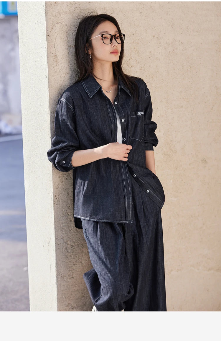 Model touching the unbuttoned shirt placket — contrast stitching visible on collar and plackets. From Borcelleclothes.