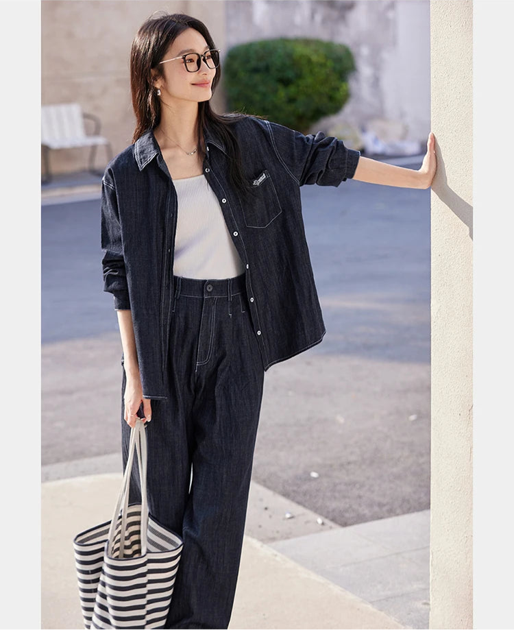 Model in Midnight Express two-piece set standing near a wall — loose-fit shirt and wide-leg trousers with soft urban presence. From Borcelleclothes.