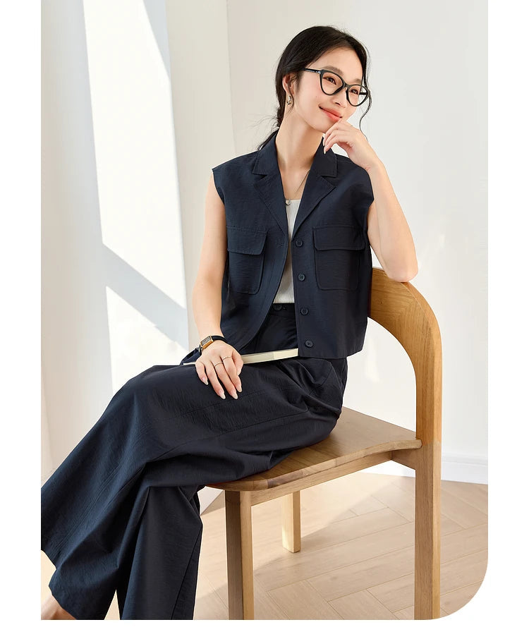 Woman sitting with legs crossed, wearing Mirage set — elegance and composure through every structured detail. From Borcelleclothes.