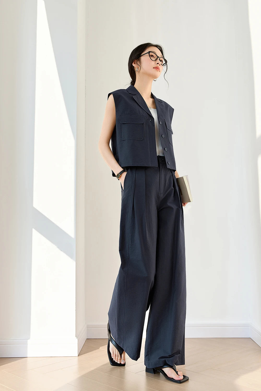 Woman taking a side step in Mirage suit, illustrating fluidity of tailored trousers and vest in motion. From Borcelleclothes.