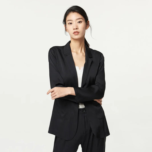 Women’s Mulberry silk satin blazer in Onyx — single-breasted with notch lapels and rounded patch pockets, cut to offer breathability, softness, and ease for warm days. From Borcelleclothes.