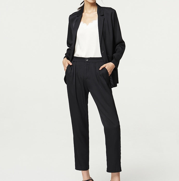 Model wearing the Onyx silk satin set with hands in pants pockets — a composed stance highlighting softness and structure in motion. From Borcelleclothes.