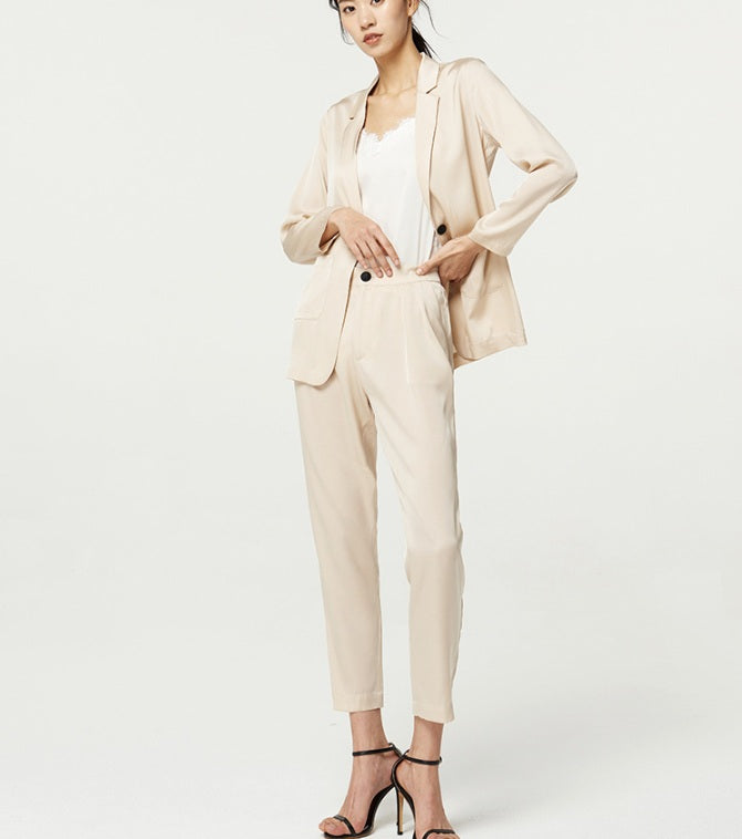 Woman in Pearl Bush satin set with one hand resting at her waist — a composed pose echoing the set’s balance of softness and structure. From Borcelleclothes.