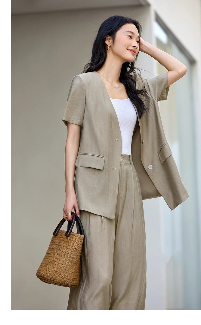 Model gently adjusting her hair, dressed in the Olive Haze set with its softly structured silhouette. From Borcelleclothes.