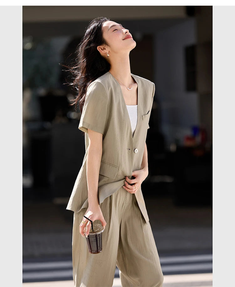 Model smiling with lifted face, embodying quiet confidence in the Olive Haze two-piece set. From Borcelleclothes.