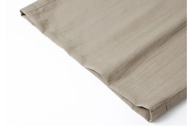 Bottom hem of the wide-leg trousers in crinkled Olive Haze fabric, softly structured. From Borcelleclothes.
