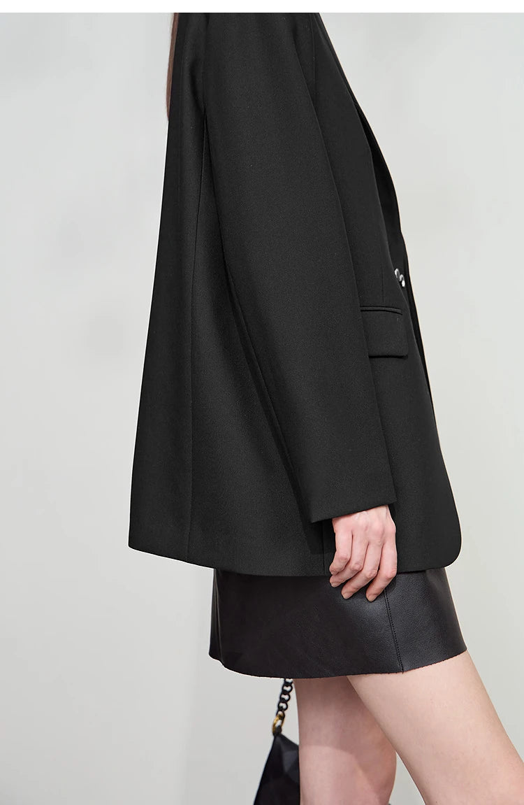 Model wearing Onyx minimal blazer, side view with thigh-length cut – From Borcelleclothes.