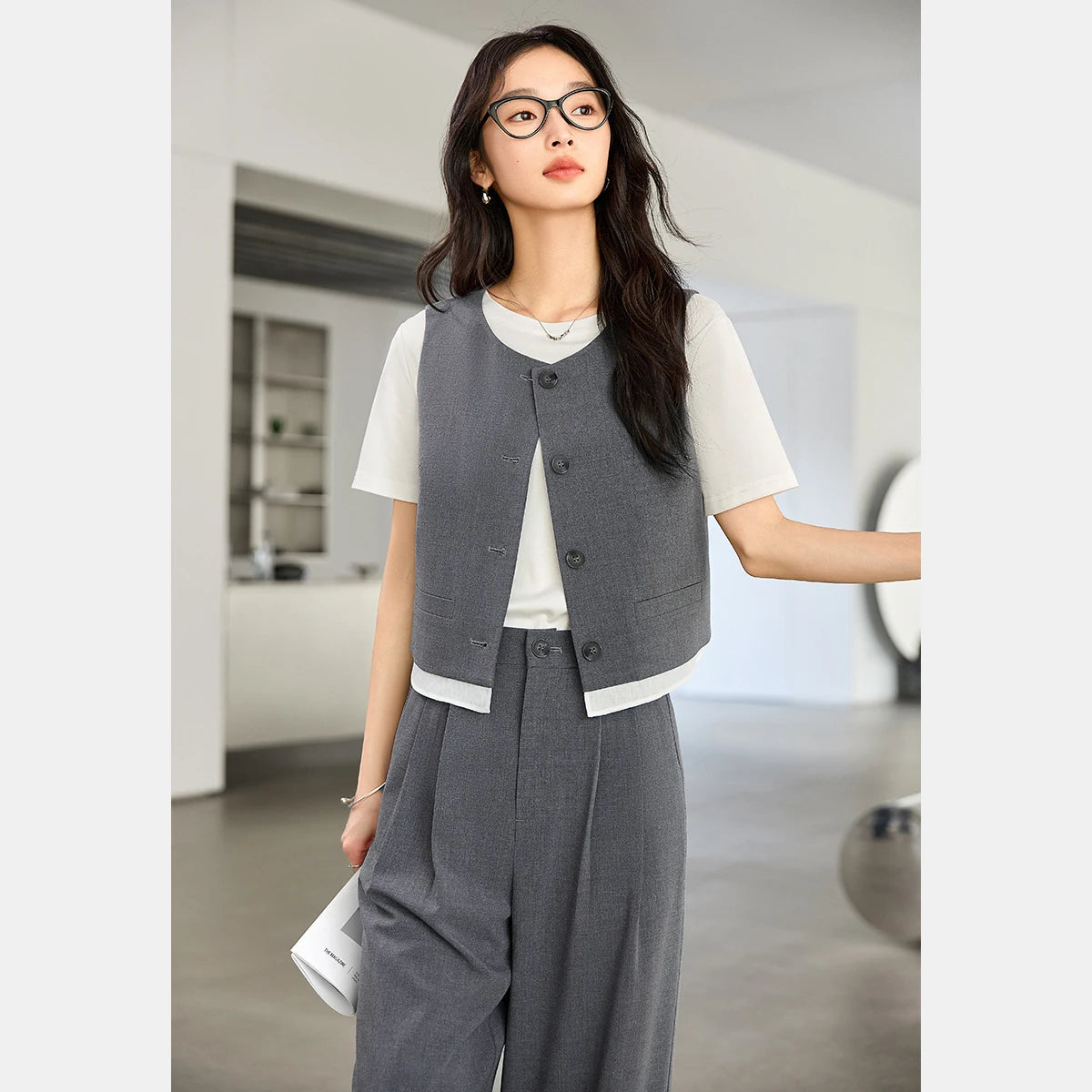 Model with one arm bent in the Payne’s Grey two-piece set, emphasizing the flow of the vest and clean tailoring. From Borcelleclothes.