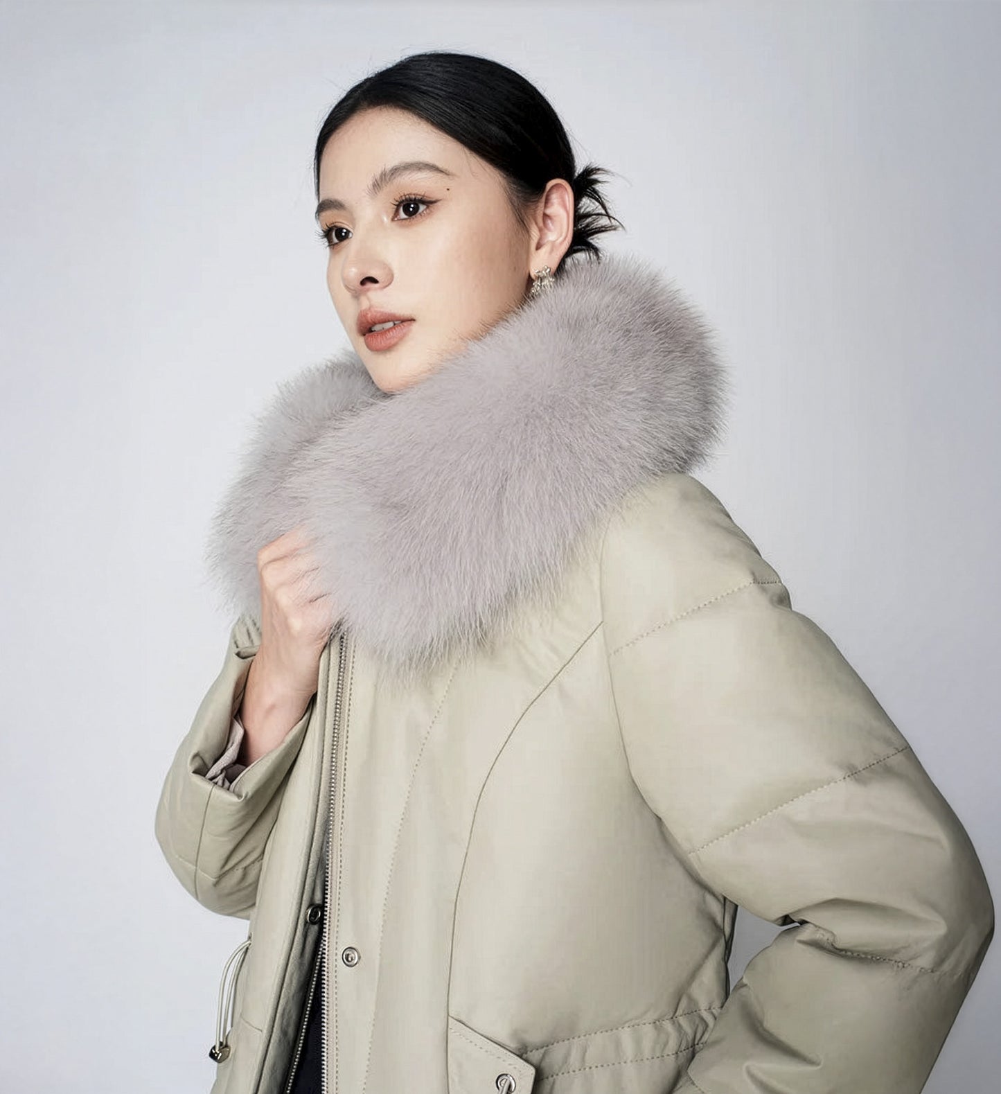Women's Sheepskin Coat with Hidden Casing in Moon Mist — unfastened, model holding collar together. From Borcelleclothes.
