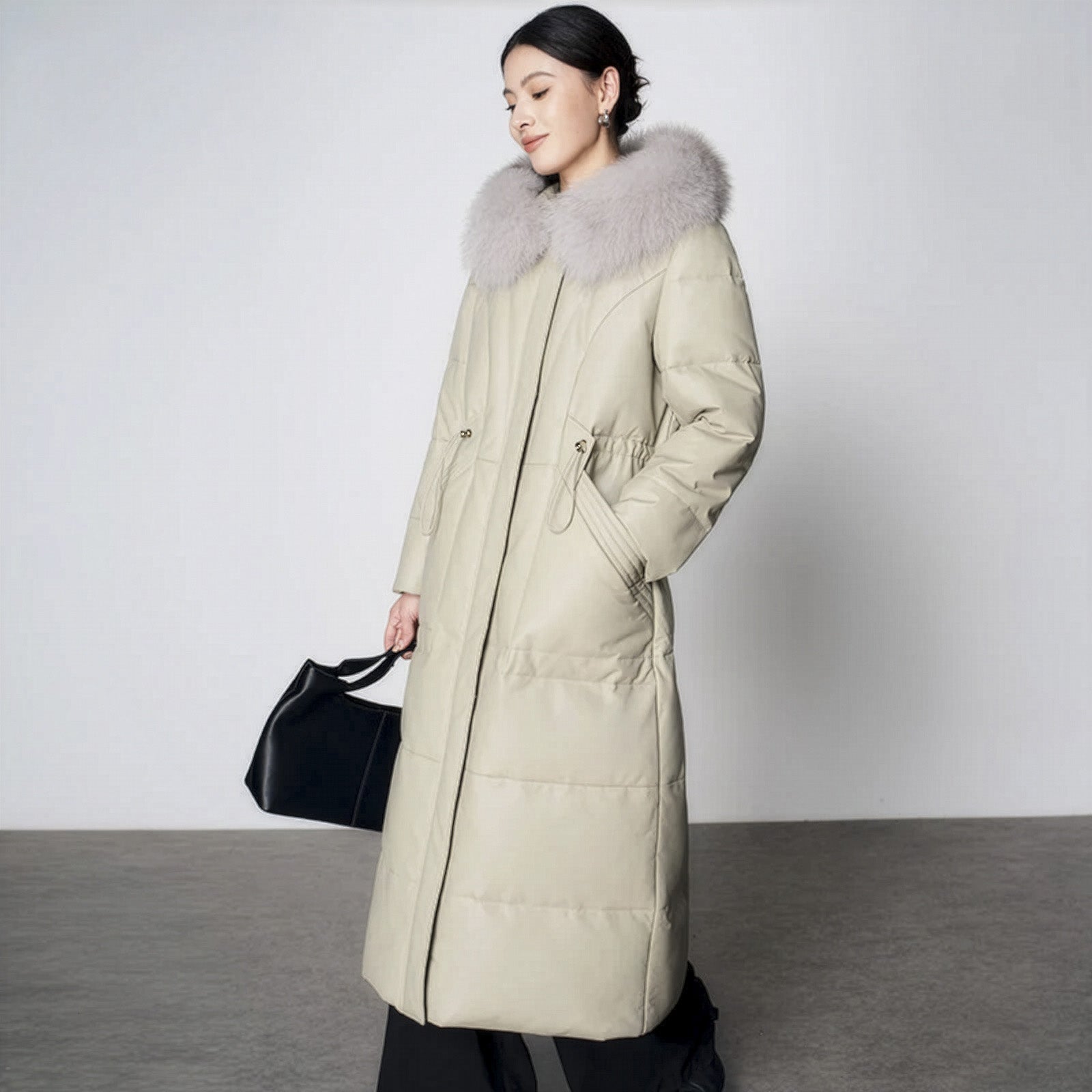 Women's Sheepskin Coat with Hidden Casing in Moon Mist. Fox-trimmed hood, hidden drawstring waist, goose down fill, mid-calf length. Borcelleclothes.