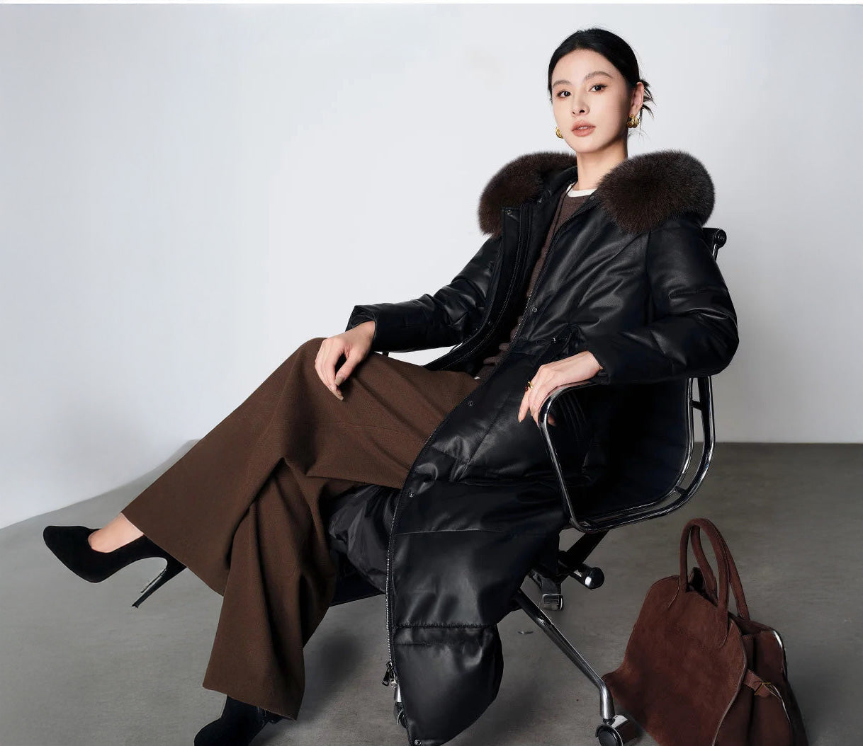 Women's Sheepskin Coat with Hidden Casing in Onyx — seated model with crossed legs. From Borcelleclothes.
