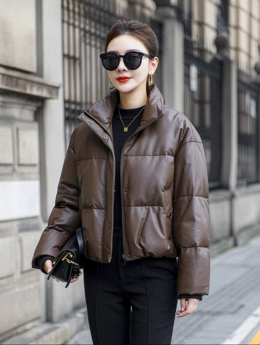 Model in Rose Ebony sheepskin puffer jacket holding a small bag, showcasing the coat's compact silhouette and soft structure. — From Borcelleclothes.