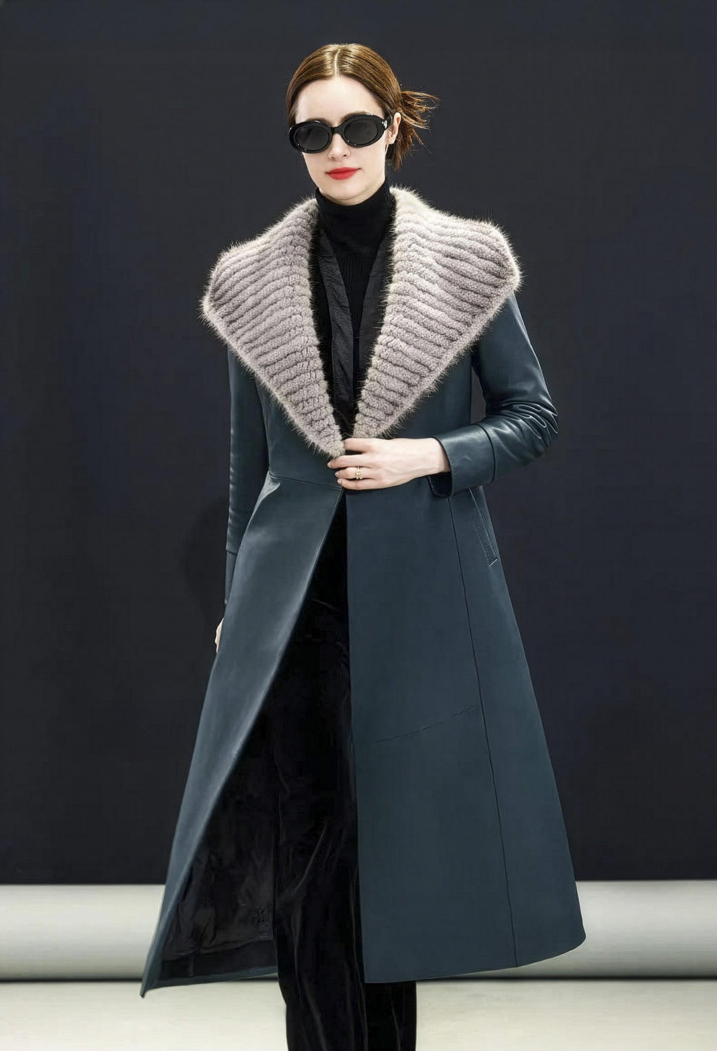 Model in Independence coat holding the collar closed gently, creating framed neckline — From Borcelleclothes.