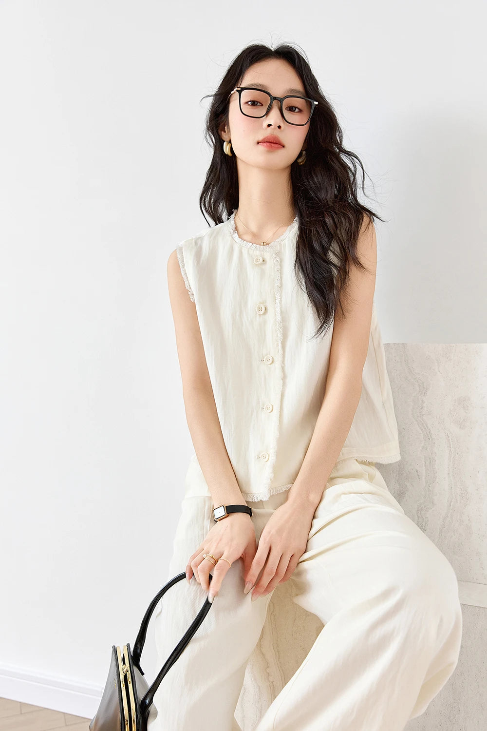 Model seated on a white couch in the Spring Wood set, exuding calm elegance. From Borcelleclothes.