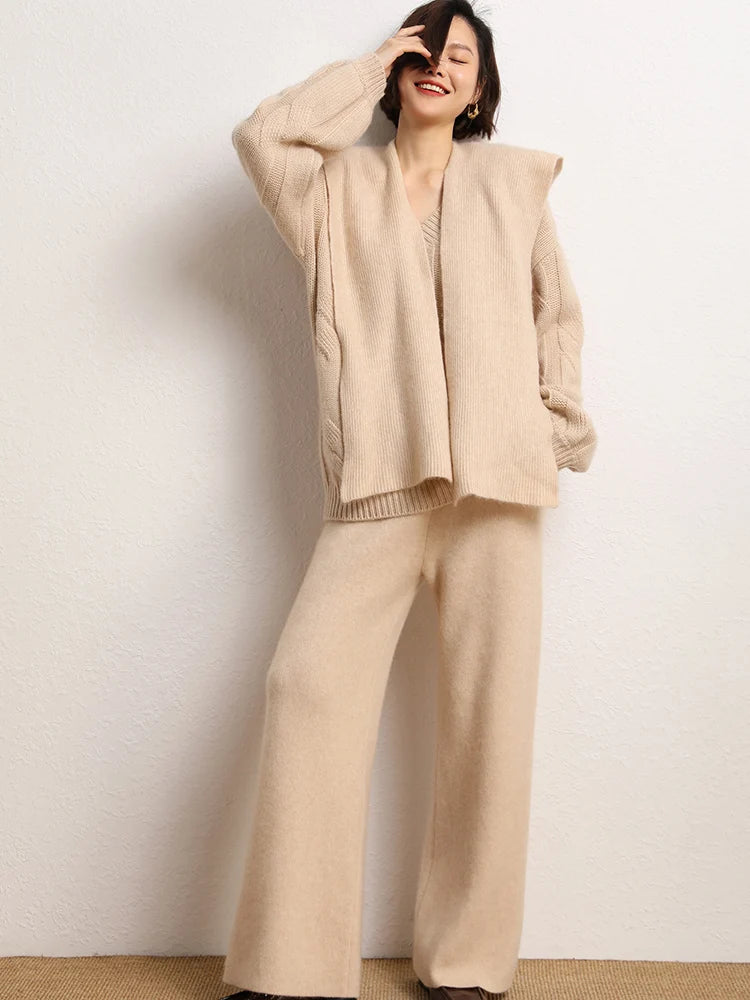 Smiling model in Desert Sand straight-cut Alashan cashmere trousers touching her hair — From Borcelleclothes.