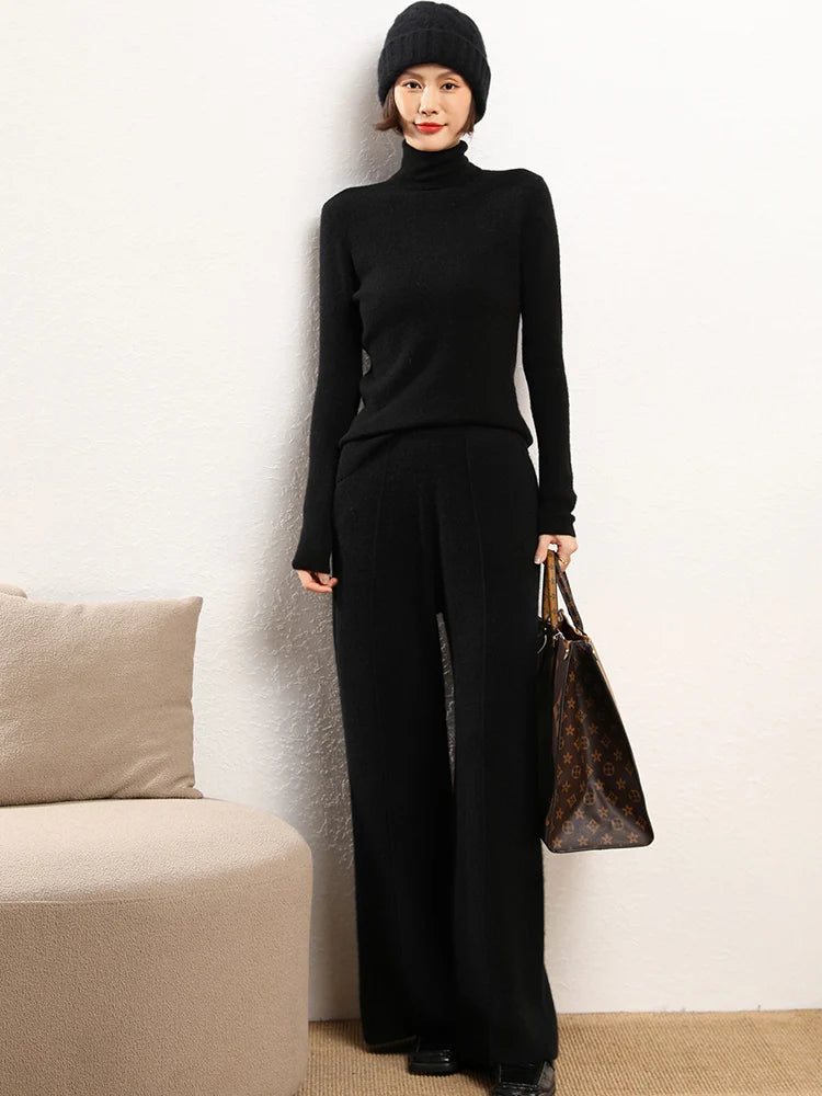Model holding an oversized bag in Onyx straight-cut Alashan cashmere trousers — From Borcelleclothes.