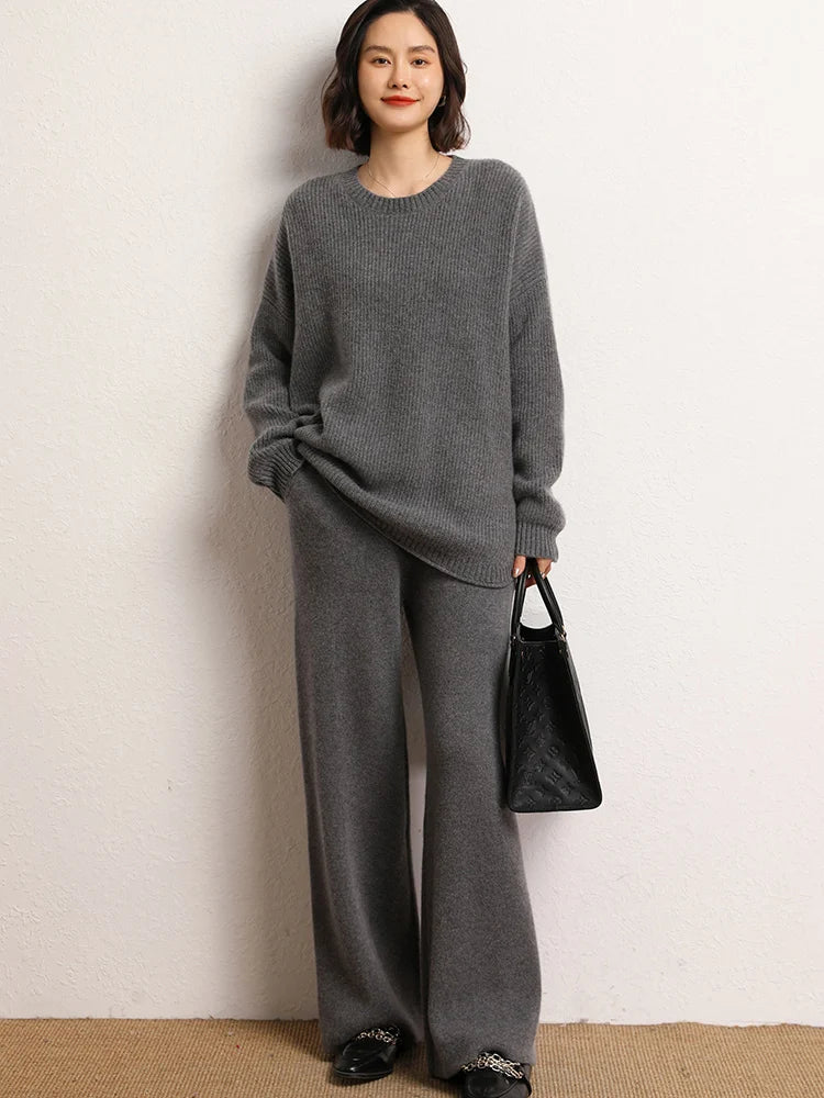 Model holding a bag while wearing Storm Dust straight-cut Alashan cashmere trousers — From Borcelleclothes.