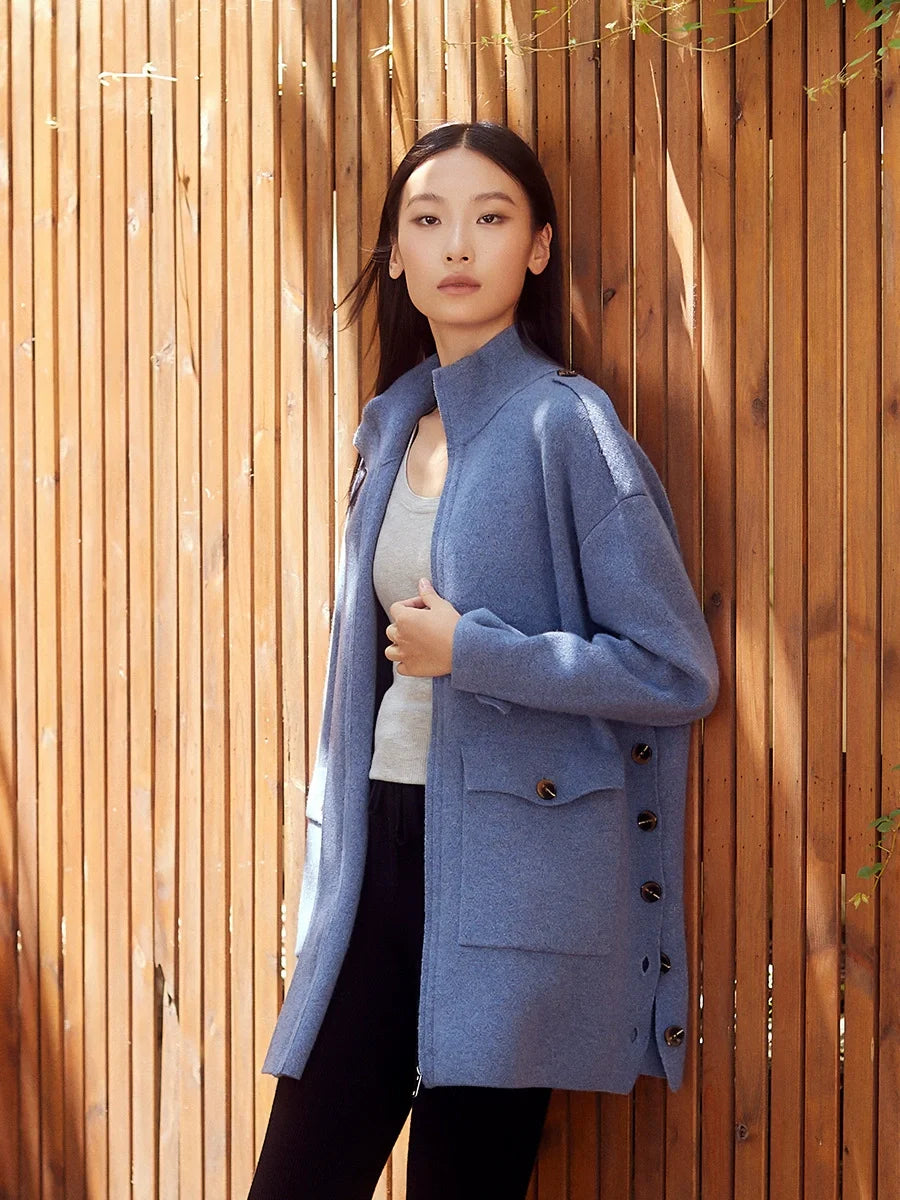 Unzipped cardigan in Frosted Blueberry with model touching the front edge, revealing soft interior structure — From Borcelleclothes.