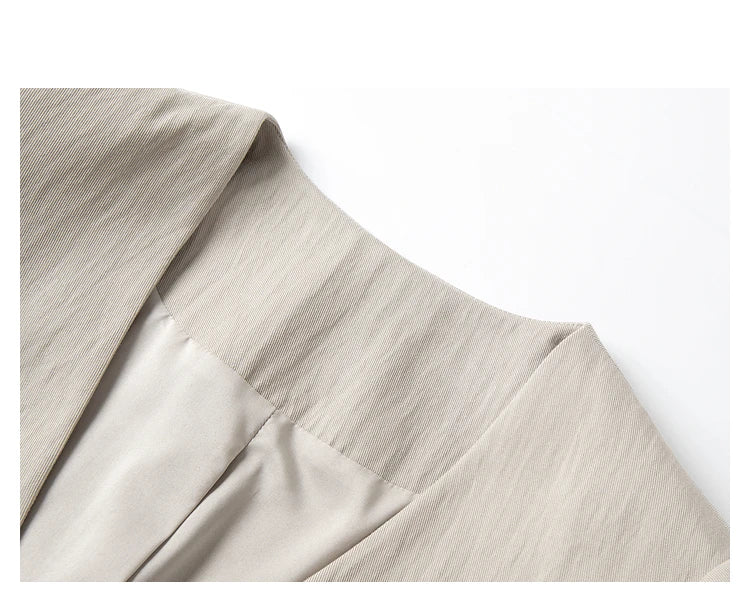 Close-up of jacket’s V-neckline — precise tailoring in soft neutral fabric. From Borcelleclothes.