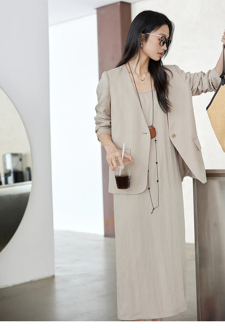 Model holding a cup of coffee — Swiss Coffee jacket and dress forming a serene morning silhouette. From Borcelleclothes.