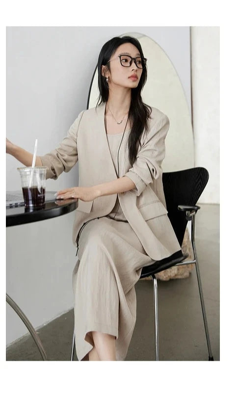 Seated model in Swiss Coffee two-piece set — relaxed posture in structured jacket and flowy dress. From Borcelleclothes.