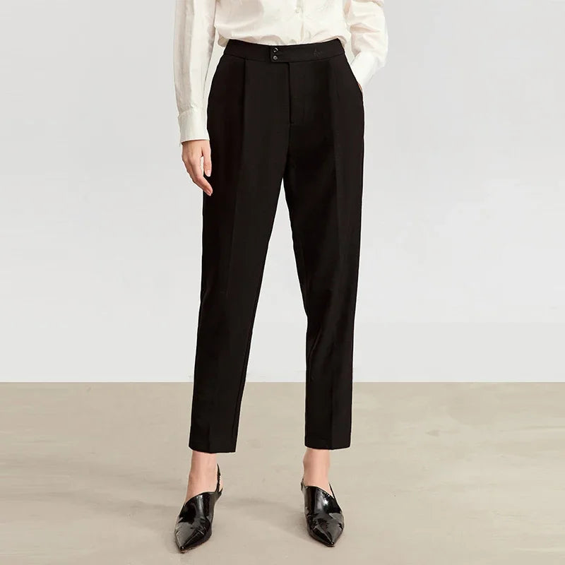 Women's tailored cropped trousers in Onyx, featuring front pleats, tonal decorative buttons, and a discreet embroidered signature at the waistband. From Borcelleclothes.