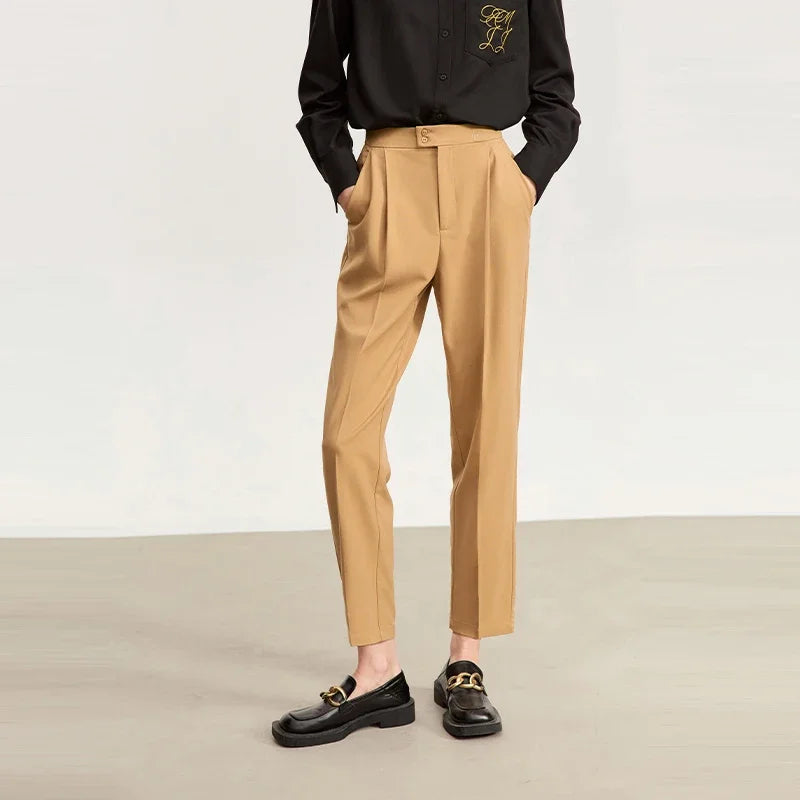 Women's tailored cropped trousers in Sand Brown, featuring front pleats, tonal decorative buttons, and a discreet embroidered signature at the waistband. From Borcelleclothes.