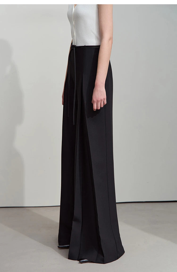 Side profile in Onyx trousers, emphasizing fluid cut and sculptural pleats. From Borcelleclothes.