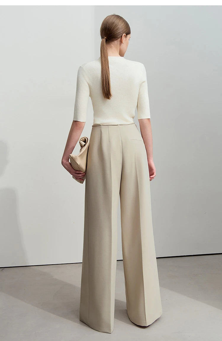 Rear view of the model in tailored trousers with relaxed drape and clean lines. From Borcelleclothes.