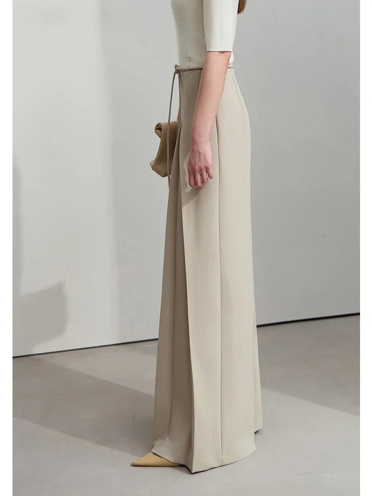 Left profile of the trousers with sculptural pleats and clean side lines. From Borcelleclothes.