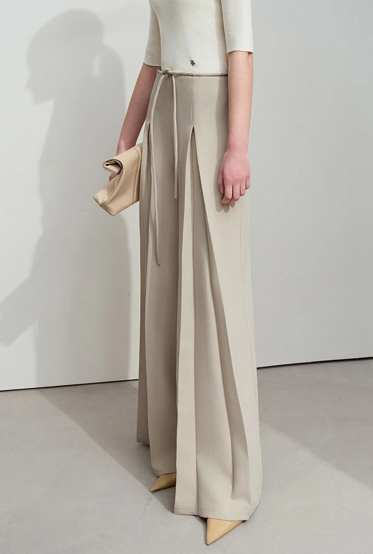 Model turned slightly to the side in draped trousers, highlighting fluid fabric movement. From Borcelleclothes.