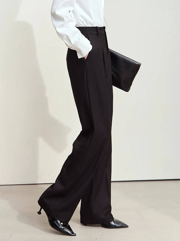 Side view of model wearing tailored loose-fitting trousers in Onyx — soft structure with modern precision. From Borcelleclothes.