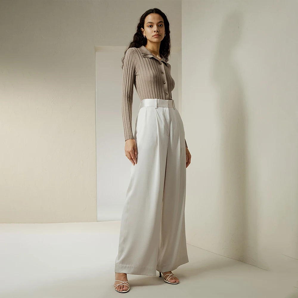 Model wearing Platinum silk trousers, slightly turned to the side, showing fluid drape and structured waist. From Borcelleclothes.