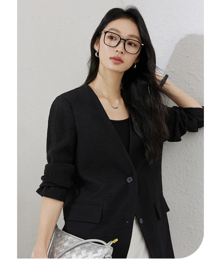 Model touching her hair in an Onyx textured pinstripe crinkle blazer. From Borcelleclothes.