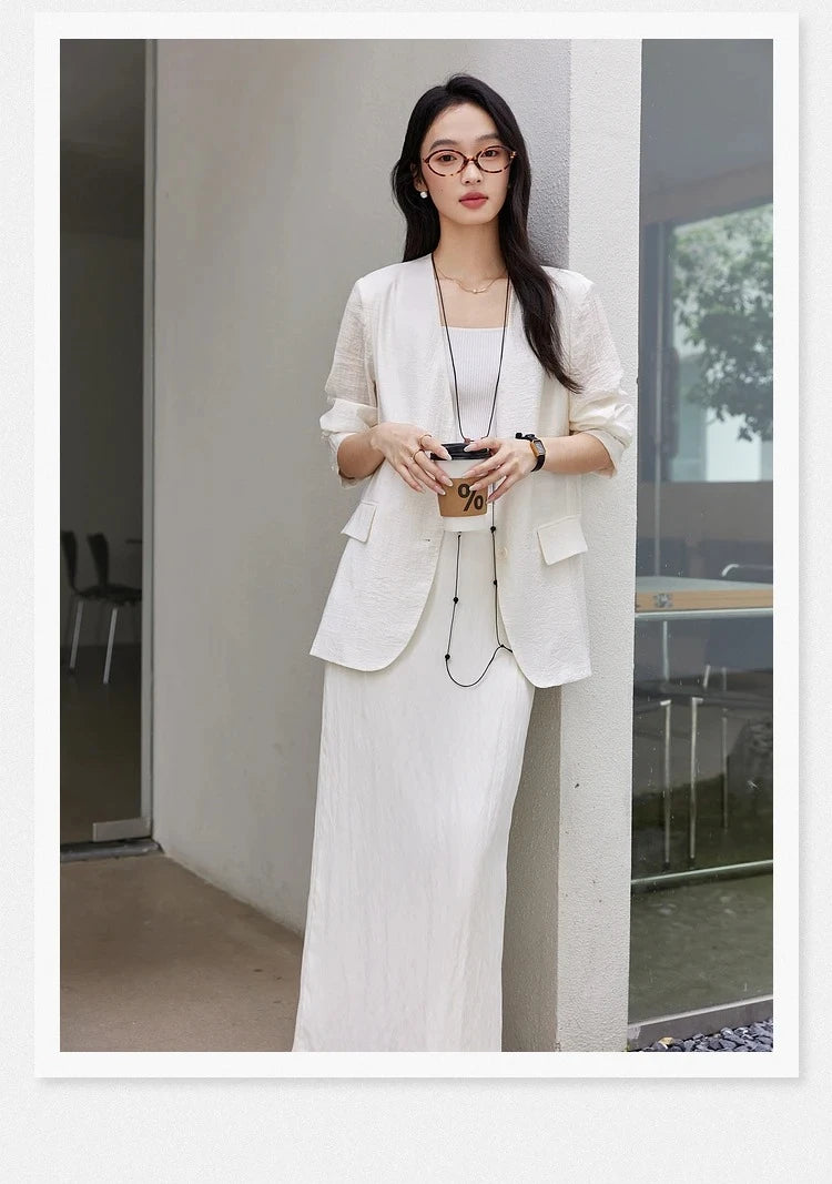 Woman holding a coffee cup while wearing a Pearl Bush textured pinstripe crinkle blazer. From Borcelleclothes.
