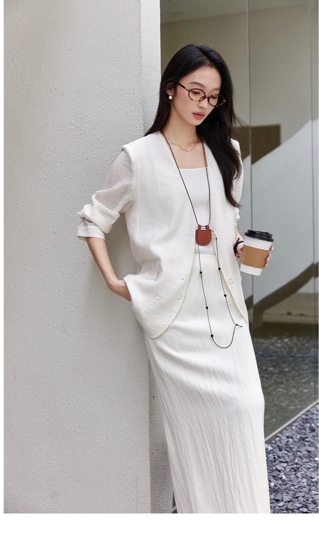 Woman in a Pearl Bush textured pinstripe crinkle blazer looking downward. From Borcelleclothes.
