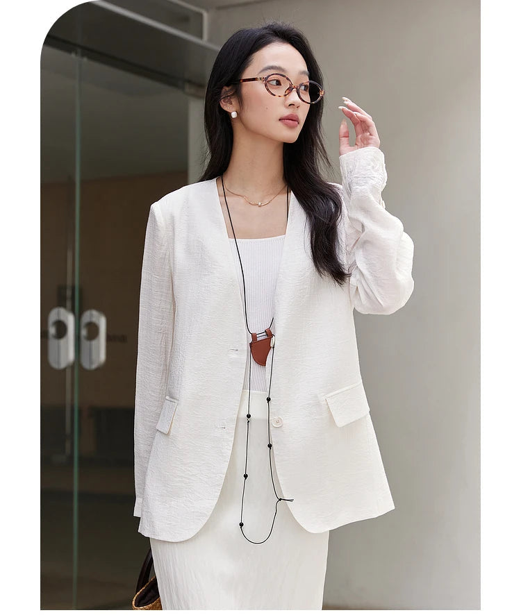 Woman in Pearl Bush textured pinstripe crinkle blazer raising her arm. From Borcelleclothes.